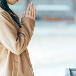 神社で祈る女性