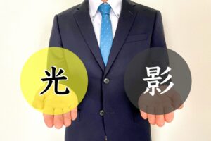 光と影を手に持つスーツ姿の男性
