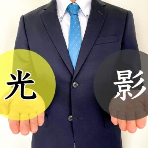 光と影を手に持つスーツ姿の男性
